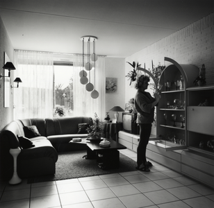 108277 Interieur van een huis aan de Zenithstraat te Utrecht: woonkamer, met de bewoonster.